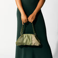 Model holding NOIRANCA handbag Patti in Olive Green with its thick matt chain