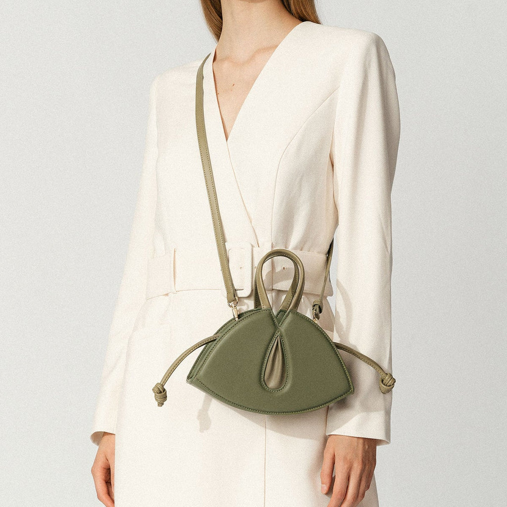 Model wearing NOIRANCA handbag Alice Mini in Olive Green with a strap